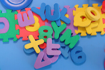Closeup of rubber alphabet and number blocks in the blue background
