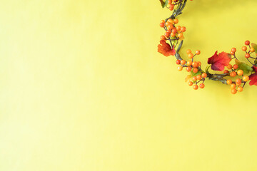 秋の実のシンプルなリース（黄色の背景・造花）