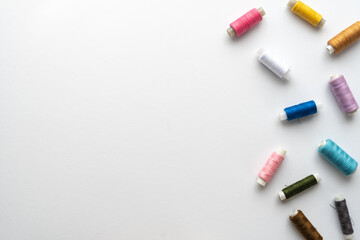 Naklejka premium Flat lay composition with sewing thread on white background. Space for text