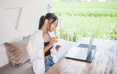 A beautiful young asian woman using and working on laptop computer.