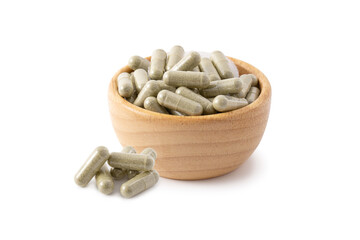 Andrographis paniculata capsule in wooden bowl with Andrographis paniculata isolated on white background, Medicine concept.