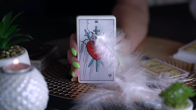  Blurred Fortune teller woman showing three of swords , reading a future by tarot cards. Esoteric concept, fortune telling and predictions. Slow motion