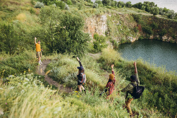 Beautiful landscape. Group of friends, young men and women walking, strolling together outskirts of...