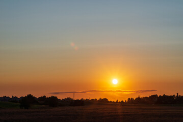 Yellow golden sunet in forest landscape.Sun in a horizon.