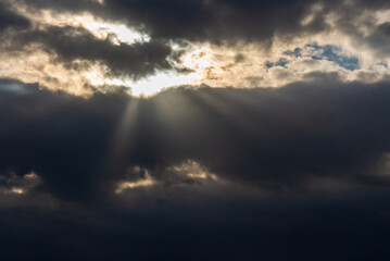 Rays of light shining throug dark clouds.Beautiful dramatic sky with sun rays.