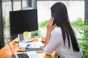 Business women using calculator and writing make note with calculate about cost at home office.