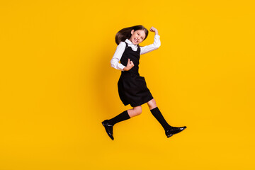 Fototapeta na wymiar Full length body size photo schoolgirl jumping up gesturing like winner happy isolated vivid yellow color background