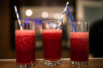 red shot glass alcohol daikiri strawberry juice soda and straw