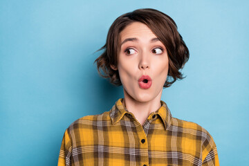 Photo of amazed funky girl open mouth look empty space wear checkered shirt isolated blue color background