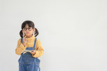 Back to school. A funny little girl in glasses on white background. Child from elementary school with a book. Education