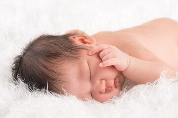 Cute newborn baby in a white blanket.