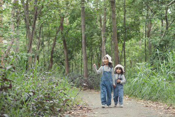 Children are heading to the family campsite in the forest Walk along the tourist route. Camping road. Family travel vacation concept.