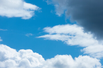 Naklejka na ściany i meble White and grey cumulus clouds on a bright sunny day