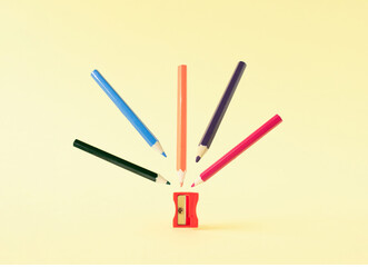 Creative arrangment of color pencils and red sharpener. Back to school minimal concept.