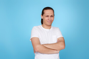 young man frowning isolated on blue background.