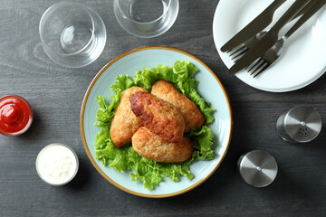 Concept of tasty food with cutlets on dark wooden table