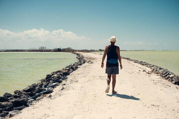 Back view of young tourist walking between two lakes. Summer vacation concept