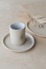ceramic cup and plates on a wooden table top view. minimalist set of handmade ceramic tableware and pottery