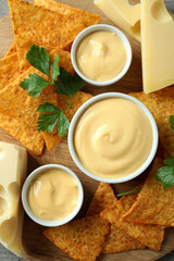 Concept of snack with chips and cheese sauce, top view