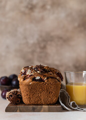 Homemade spicy plum cake decorated with almond on a wooden serving board, concrete background. Loaf cake with plum, spices and almond.