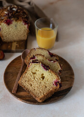Fototapeta na wymiar Homemade spicy plum cake decorated with almond on a wooden serving board, concrete background. Loaf cake with plum, spices and almond.