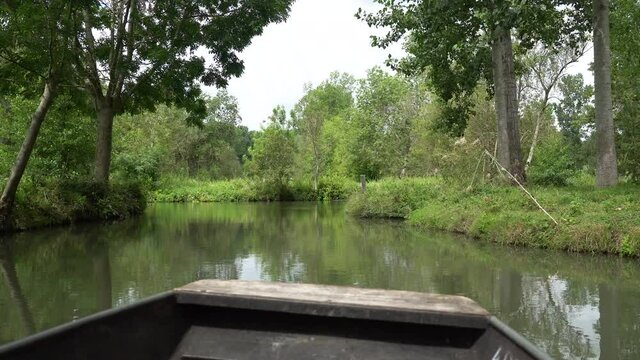 Sailing by boat on the natural water channels between La Garette and Coulon, Marais Poitevin the Green Venice, near the city of Niort, France
