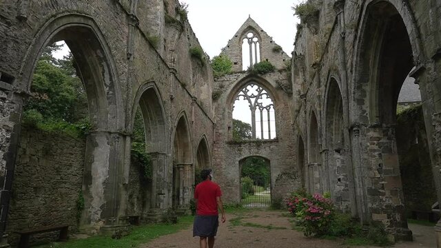 A young man visiting the interior gardens of the Abbaye de Beauport in the village of Paimpol, Ctes-d'Armor department, French Brittany. France