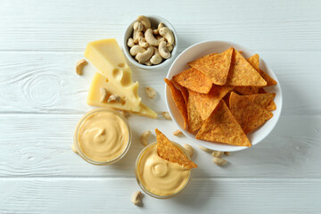 Snacks with cheese sauce on white wooden table