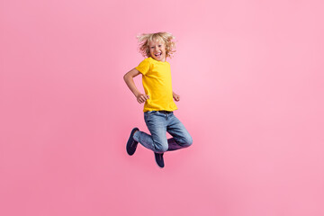 Fototapeta na wymiar Full size profile side photo of young cheerful little boy happy positive smile jump up isolated over pink color background