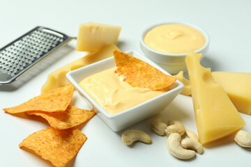 Bowl of cheese sauce and ingredients on white background