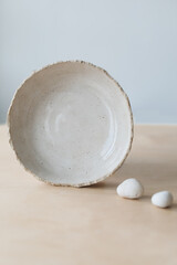 Ceramic bowl on a wooden table top view. Handmade ceramic tableware and pottery