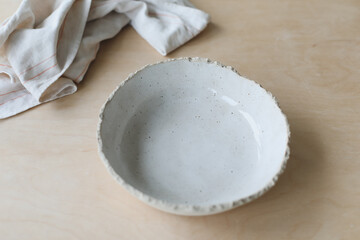 Ceramic bowl on a wooden table top view. Handmade ceramic tableware and pottery