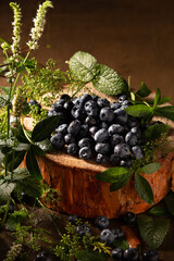 Ripe blueberries and mint on brown background