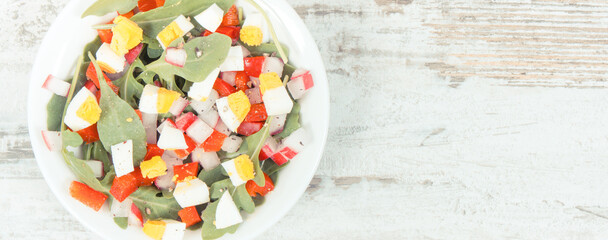 Fresh salad in glass bowl, healthy nutrition concept, copy space for text on rustic board