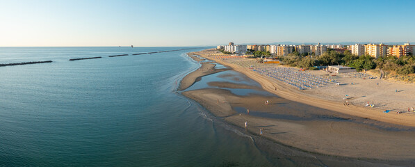 Aerial view of sandy beach with umbrellas and gazebos.Summer vacation concept.Lido Adriano...