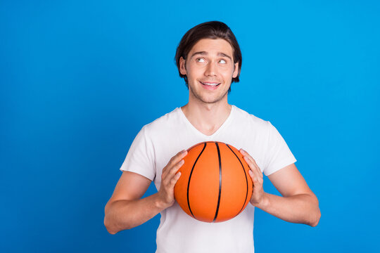 Photo portrait brunet man looking copyspace keeping ball isolated bright blue color background