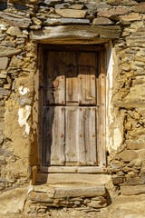 Old wooden door in medieval stone house.