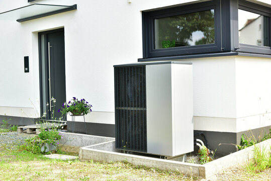 Luftwärmepumpe/Klimaanlage für Heizung und Warmwasser vor einem Wohnhaus