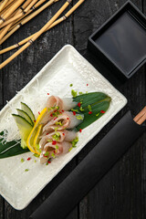 Sashimi on a plate on a dark table. Japanese cuisine
