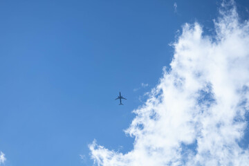Naklejka na ściany i meble airplane in the blue sky with clouds