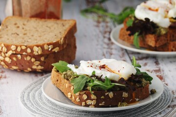 Homemade sandwiches with pesto, green salad and poached eggs	