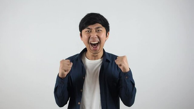 Man sreaming and feeling very angry at face show fists up,Asian man shout very loudly white background slow motion