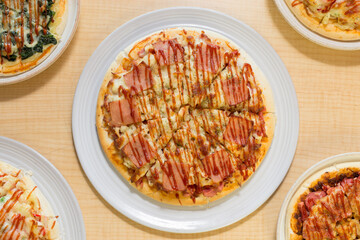 Italian pizza in white plate on wooden table