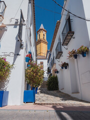 Typical Andalusian street in Estepona with the Parish Church of Nuestra Señora de los Remedios in the background