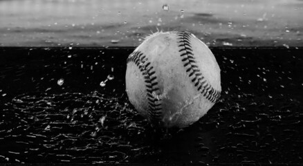 Baseball with water splash shows action for sport with ball in black and white.