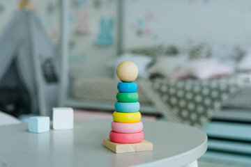 Wooden toy pyramid and blocks on the table