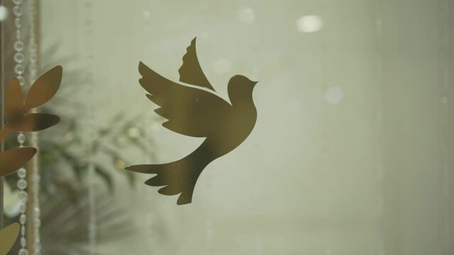 The dove is a symbol of peace. Golden bird emblem on a transparent background. Decor element of the festive fossil photo zone