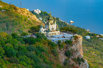 Fototapeta na wymiar Beautiful mountain landscape, the Church of the Holy Resurrection of Christ on the Red Cliff near the village of Foros on the Crimean coast of the Black Sea. The view from the height of bird flight.