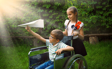 Girl rolls a boy in a wheelchair