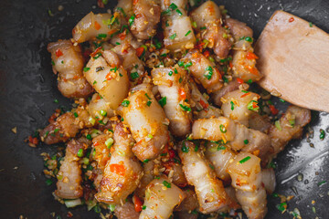 Stir fried pork belly slice with chili and salt in a black pan. Deliciousness of asian food. Thailand street food.